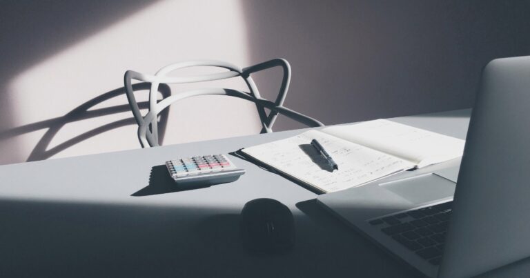Bureau avec calculatrice, ordinateur portable et carnet de notes, illustration du calcul du ROI de la marque employeur en 2026