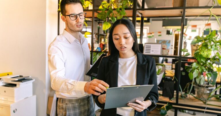 Tuteur et alternante analysant un document dans un bureau lumineux, alternance et marque employeur
