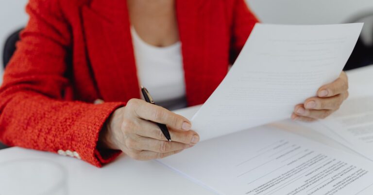Audit marque employeur : une dirigeante en veste rouge passe en revue la grille de diagnostic en 10 questions
