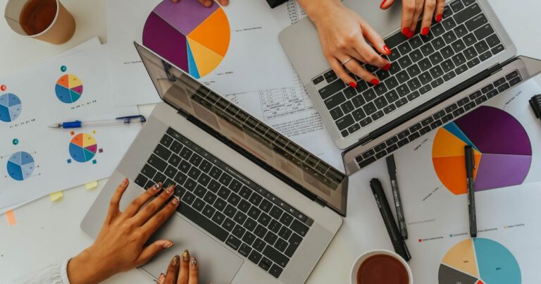 Budget marque employeur 2027 : vue de dessus d'une équipe qui analyse des graphiques et des budgets sur ordinateurs portables