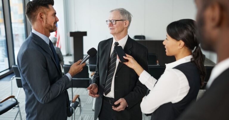 Un dirigeant interviewé par des journalistes dans un bureau, illustrant le dirigeant comme média employeur