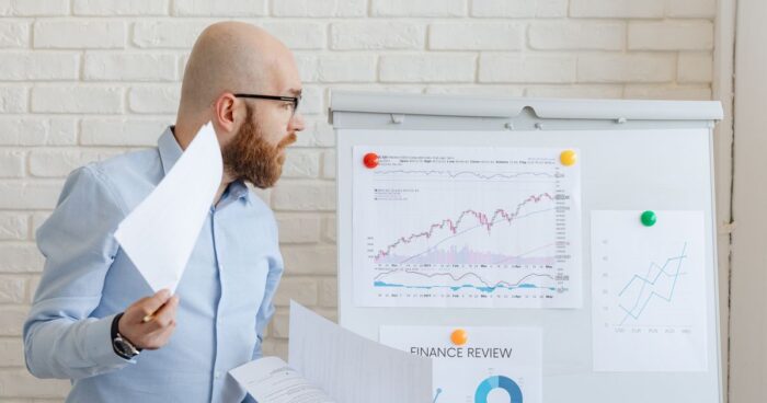 Un analyste examine des graphiques affichés au mur, illustrant l'enquête d'image employeur