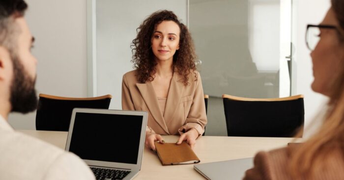 Feedback candidat après entretien : une candidate face au jury de recrutement en salle de réunion