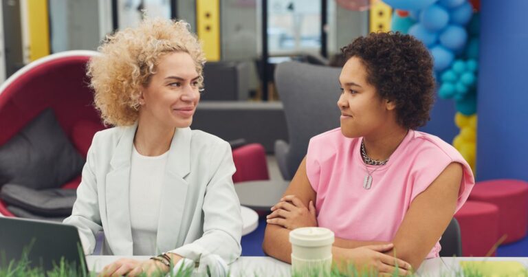 Fidélisation des talents : une manager et une collaboratrice échangent lors d'un entretien de carrière dans un espace de travail coloré