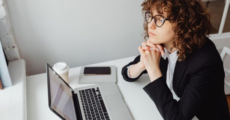 Cadre pensive a son bureau, illustration du job hugging et de la retention subie en 2026