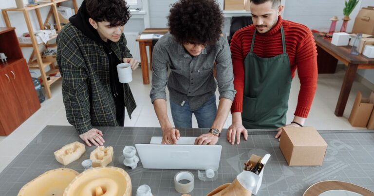Trois collaborateurs d'une PME travaillant ensemble dans un atelier, illustrant la marque employeur des PME et ETI