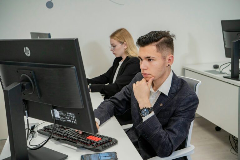 Jeune alternant au poste de travail aux côtés d'une tutrice
