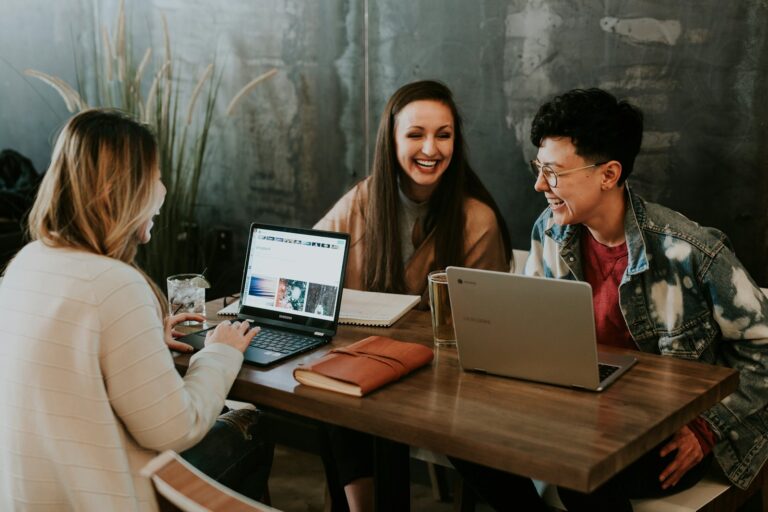 Trois collègues collaborent autour d'ordinateurs portables
